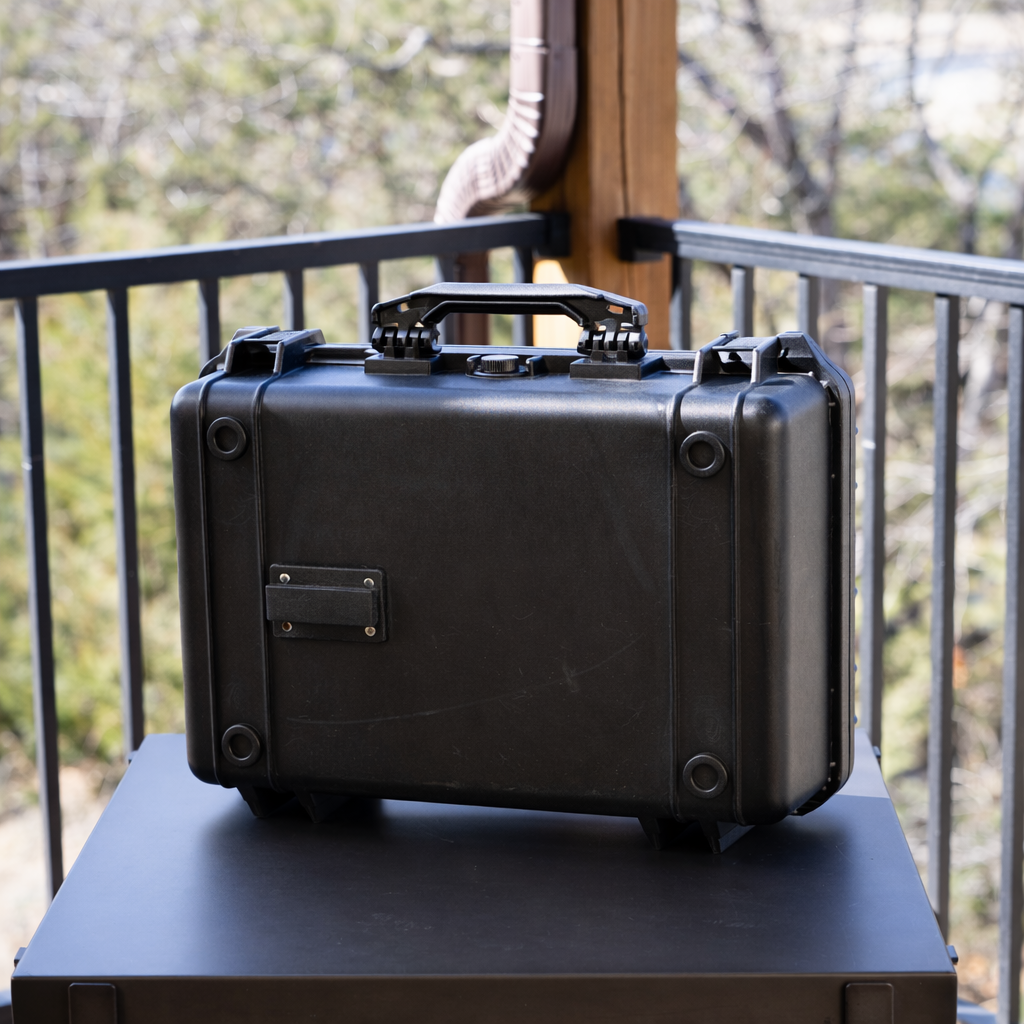 Rugged black waterproof lockbox with reinforced corners, carrying handle, and Marina Mount attachment plate