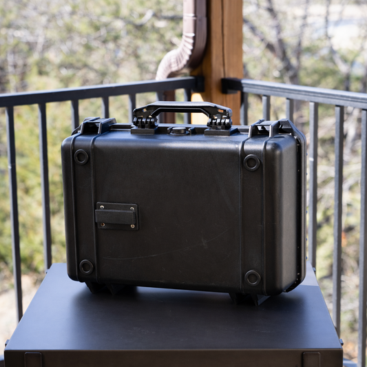 Rugged black waterproof lockbox with reinforced corners, carrying handle, and Marina Mount attachment plate